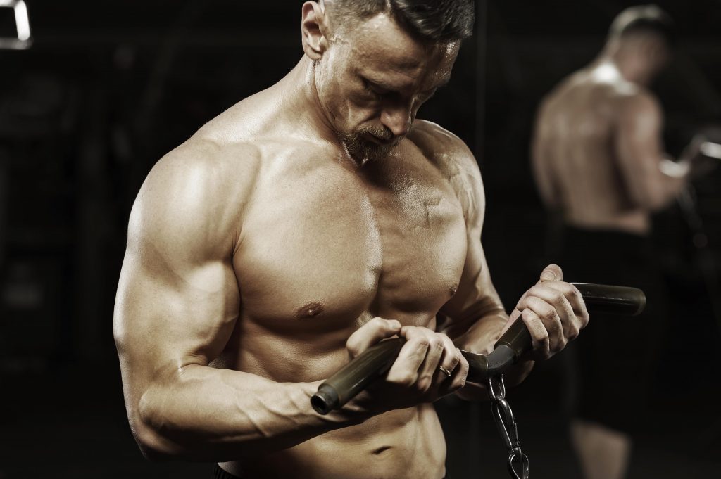 Male bodybuilder working out in machine